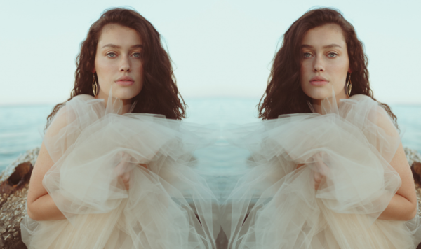 Model on beach wearing champagne tulle dress by the lotus bloom co.