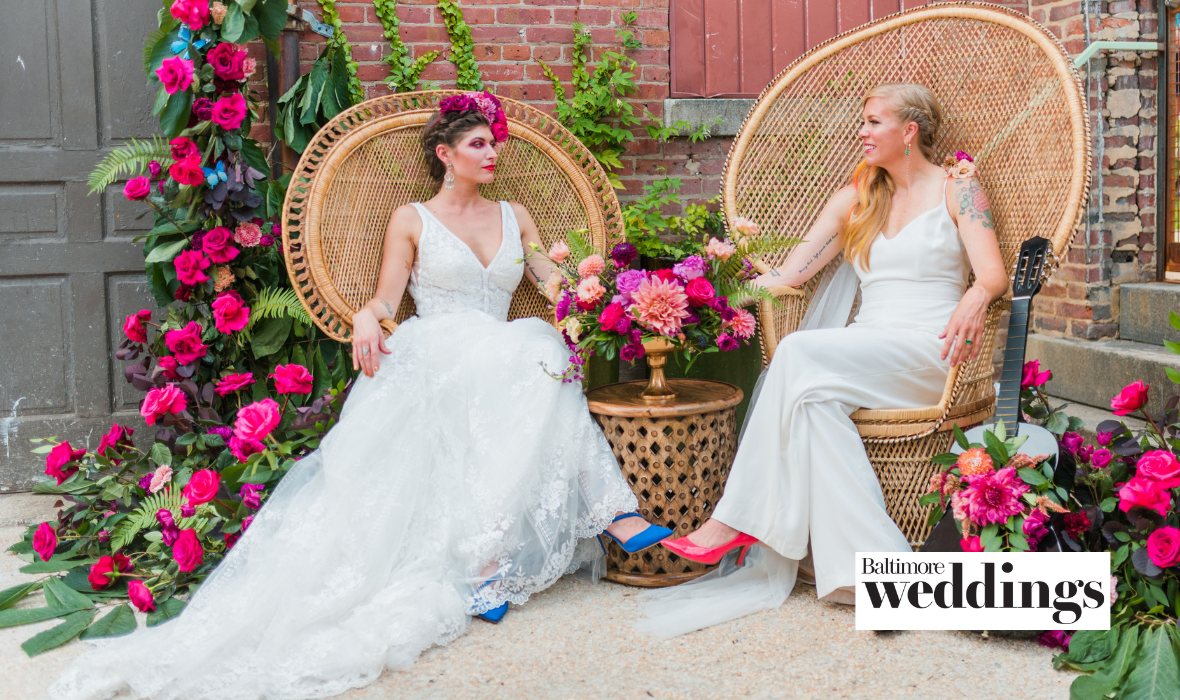 Two models sitting wearing a wedding dress and bridal jumpsuit.
