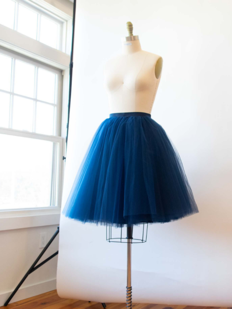 Dark blue midi tulle skirt by the lotus bloom co. on a dress form.