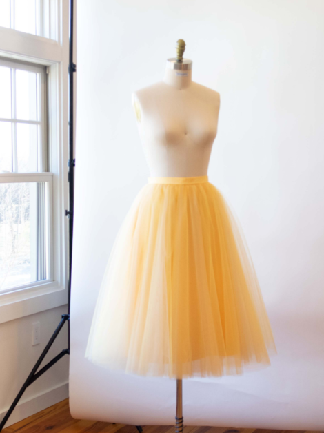 Yellow tea-length tulle skirt by the lotus bloom co. on a dress form.