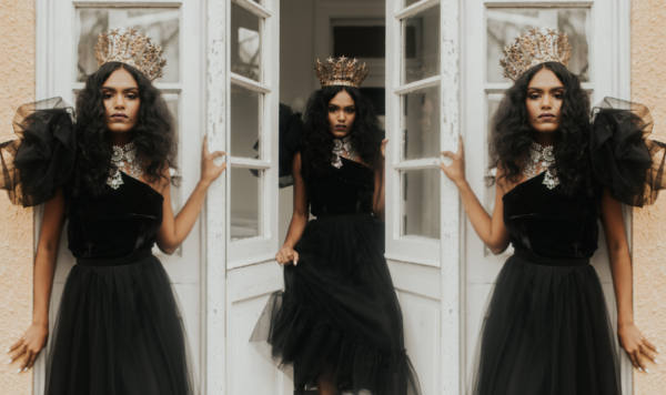Model wearing gold crown and black asymmetrical velvet and tulle dress any the lotus bloom co.